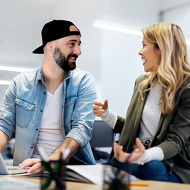 Felix Welberg und eine Kollegin arbeiten gemeinsam konzentriert an einer Aufgabe und repräsentieren die Ausbildungsmöglichkeiten bei der Netigo GmbH; das Bild vermittelt Teamarbeit, praxisnahe Lernumgebung und Engagement in einem modernen Arbeitsumfeld.